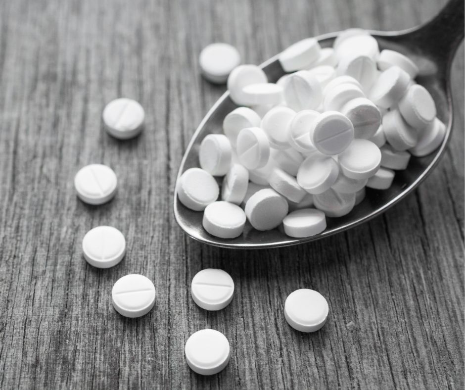Pills falling out of a spoon.